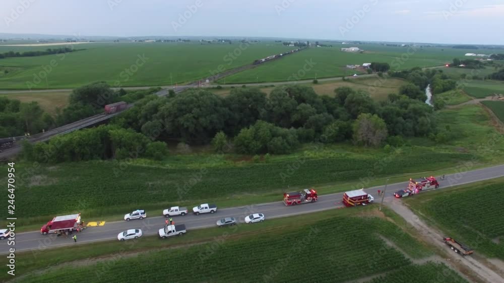 Emergency vehicles parked along rural road near train derailement 
