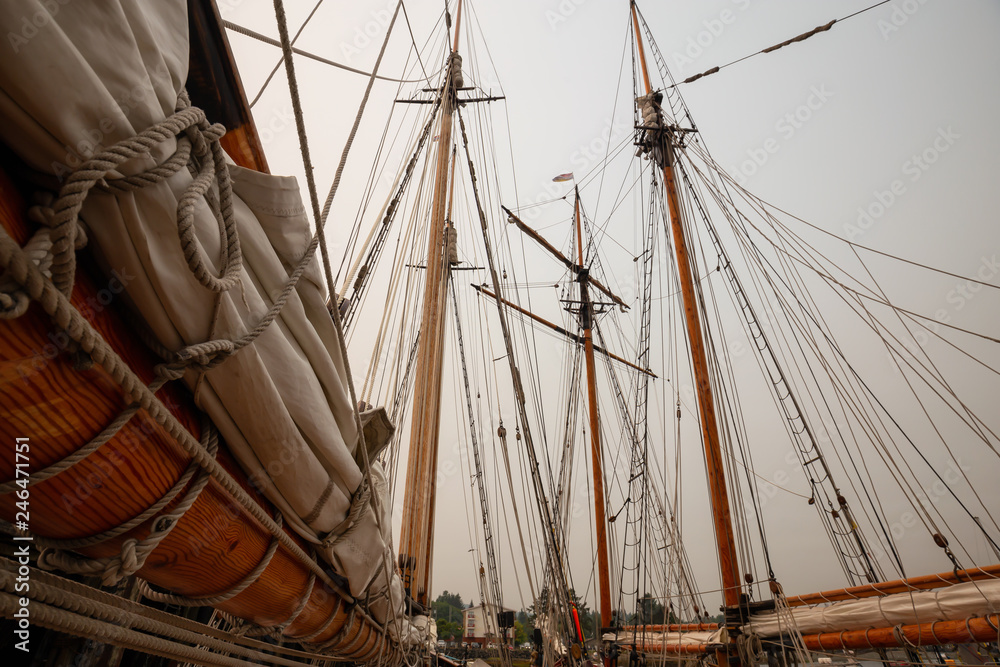 Fototapeta premium Port Hardy, Vancouver Island, BC, Canada - August 20, 2018: Wooden sailboat parked at a marina during a foggy summer day.