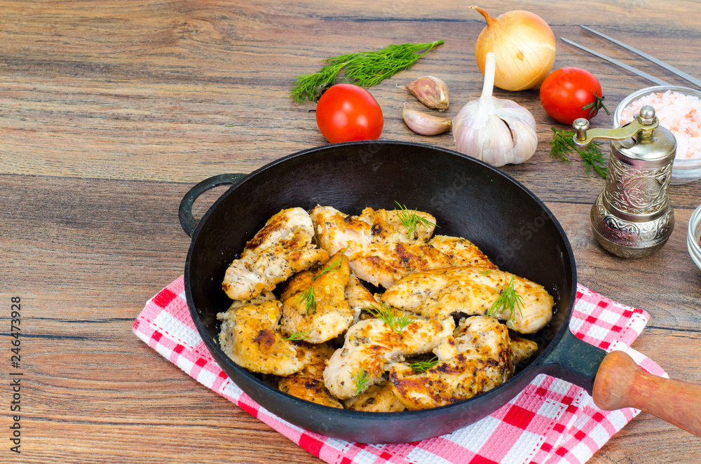Pan with fried pieces of meat on wooden table Pan with fried pieces of meat on wooden table