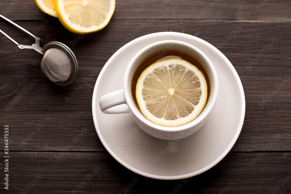 Black tea with lemon on a wooden background Black tea with lemon on a wooden background