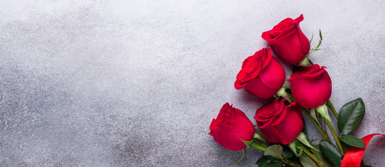 Red rose flowers bouquet on stone background Valentine's day greeting card Copy space Flat lay Horizontal banner