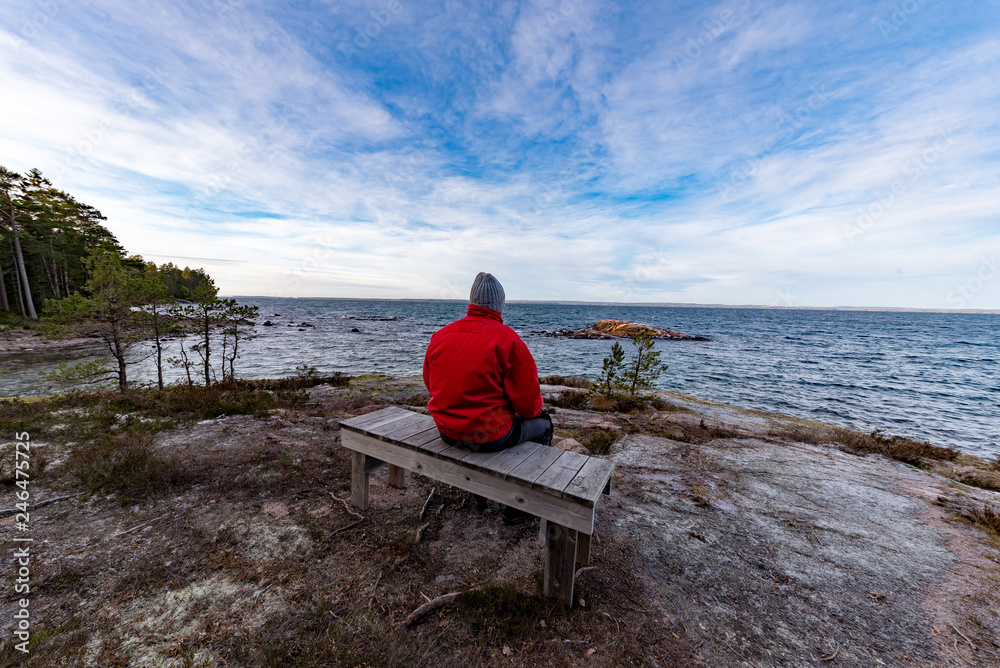 Fototapeta premium man in red jacket sitting on a bench