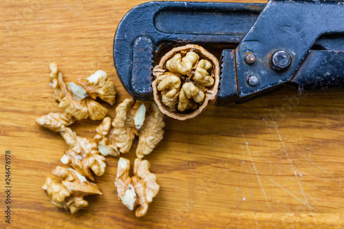 Fresh walnuts on a wooden table with nutcracker.