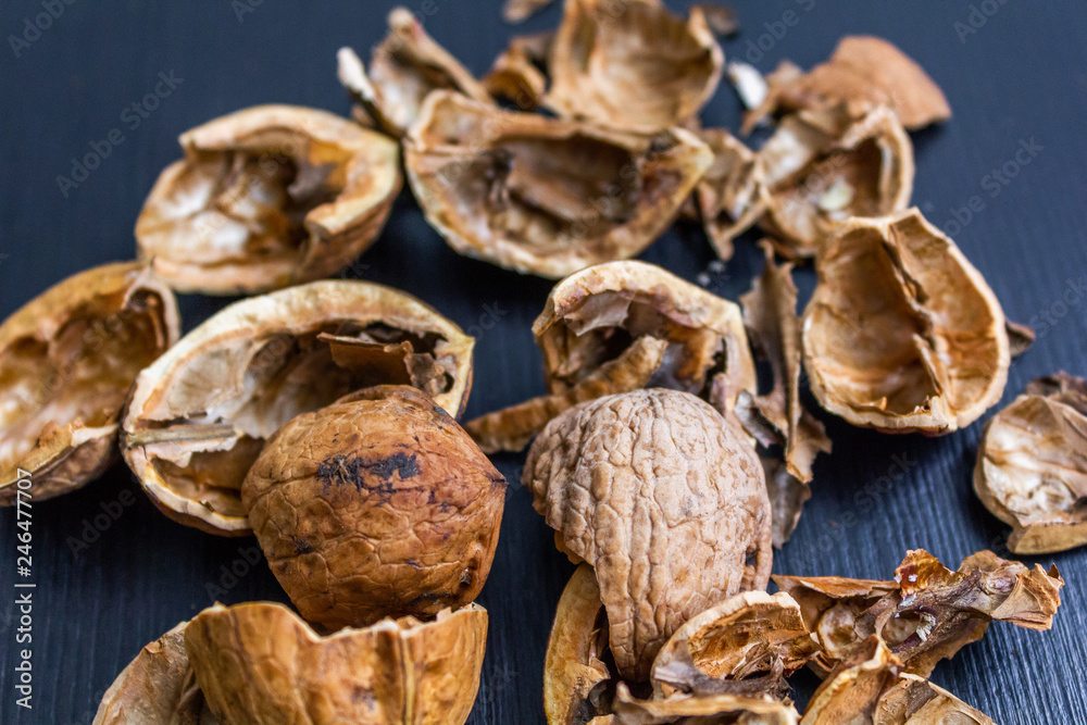 Top view of cracked walnuts shell on wooden background. Top view of cracked walnuts shell on wooden background.