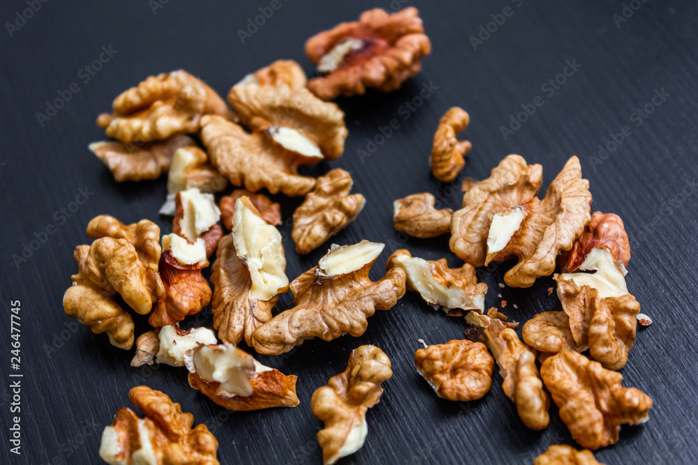 Close up of healthy brown walnuts scattered on the wooden table.