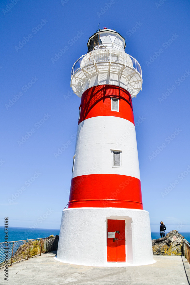 View of red and white Cape Palliser Lighthouse on the south of North Island, New Zealand.