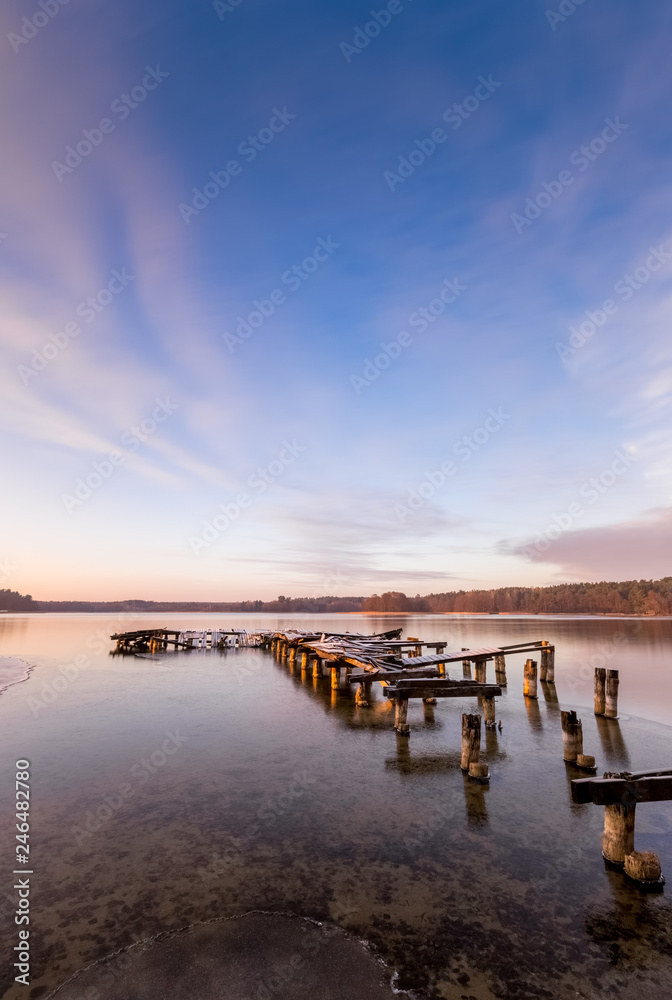 An old pier on the lake just before sunset in winter