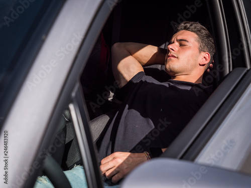 Young handosme man sleeping inside his car, exhausted, tired © starsstudio