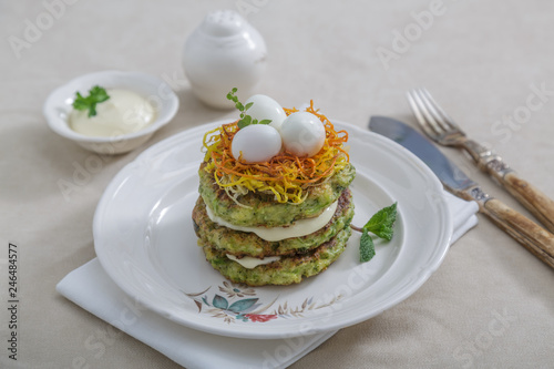 Vegetarian zucchini pancakes, served with quail eggs and carrots and yoghurt, copy space