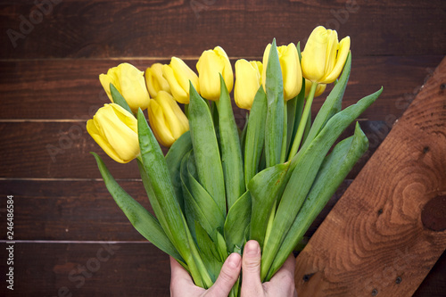 Beautiful yellow tulips on wooden background