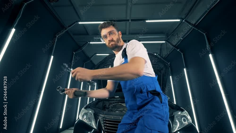 Funny service worker is dancing in front of a vehicle Funny service worker is dancing in front of a vehicle