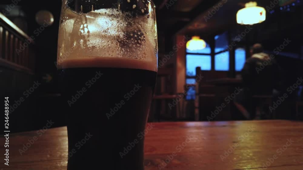 Pan left across Irish pub and stout black beer.