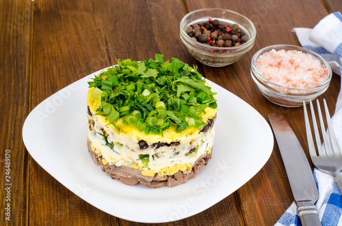 Layered portion salad with meat  cucumber  egg and mayonnaise