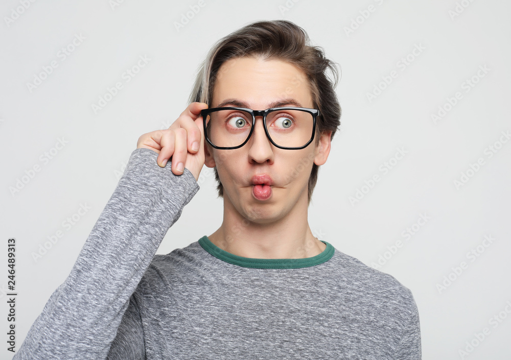 young attractive man wearing yellow sweater astonished and amazed in shock and surprise face expression   isolated on white  background 
