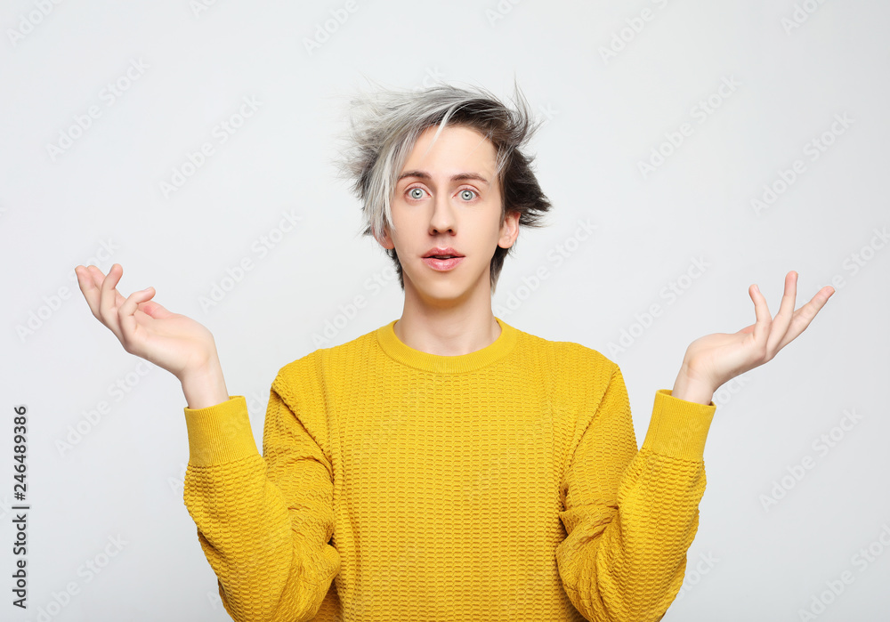 young attractive man wearing yellow sweater astonished and amazed in shock and surprise face expression isolated on white background young attractive man wearing yellow sweater astonished and amazed in shock and surprise face expression isolated on white background
