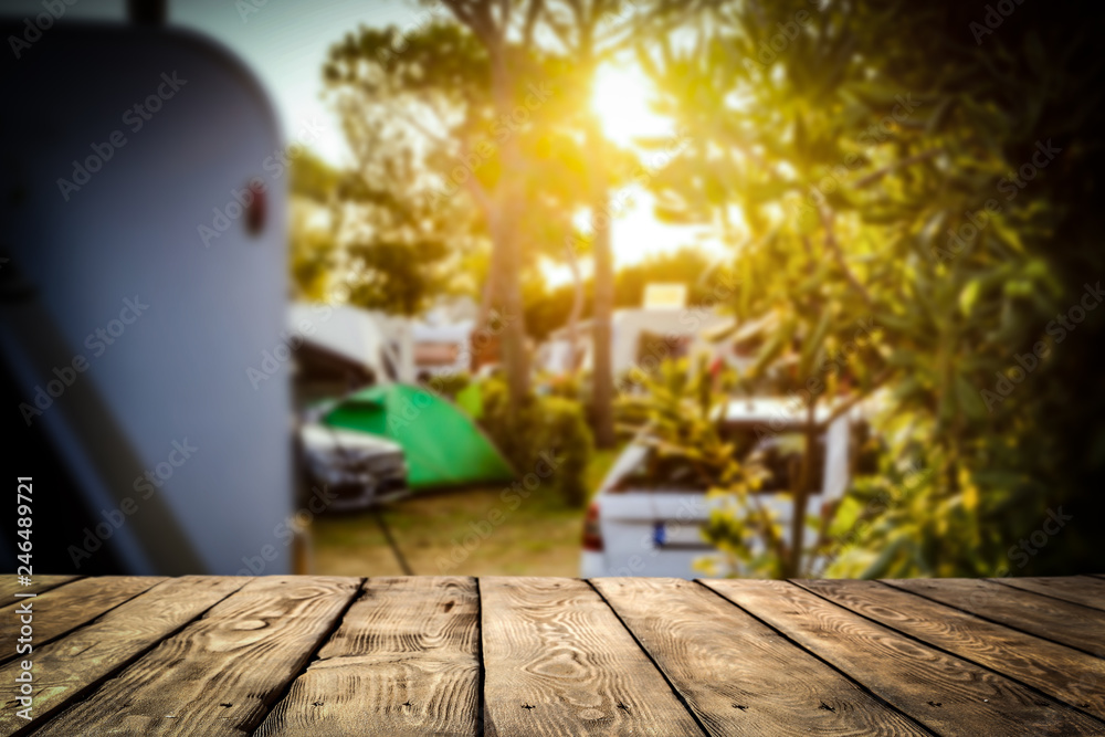 A campsite in a sunny place with a wooden board for an advertising product    - obrazy, fototapety, plakaty 