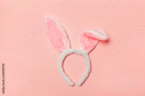 Happy Easter concept. Preparation for holiday. Decorative bunny ears furry fluffy costume toy isolated on trendy pastel pink background. Simple minimalism flat lay top view copy space