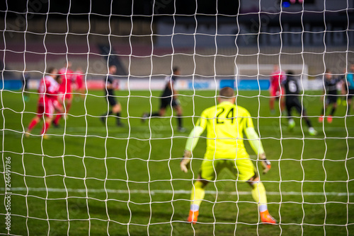 Football goalkeeper  soccer game in background