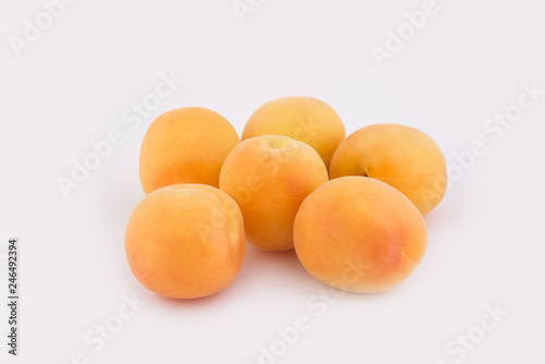 Six apricots lie side by side isolated on white background. Close-up photo