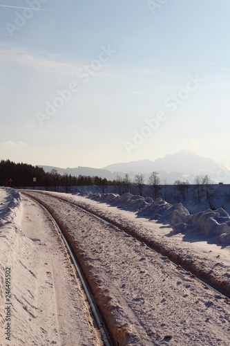 Verschneite Bahngleise in sonniger Winterlandschaft, Grünten im Hintergrund, Allgäu, Bayern © Andie_Alpion