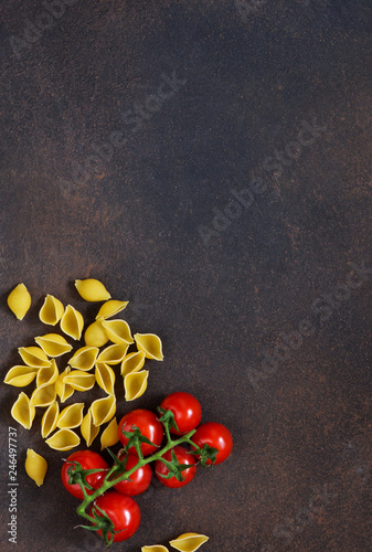  Pasta and tomatoes on a concrete background. Italian food background. Ingredient for cooking.