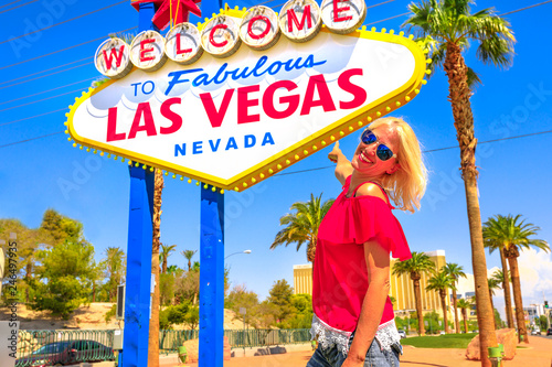 Photography Happy tourist woman pointing Welcome to Fabulous Las Vegas Nevada Sign, landmark on Las Vegas Strip at entrance of the city