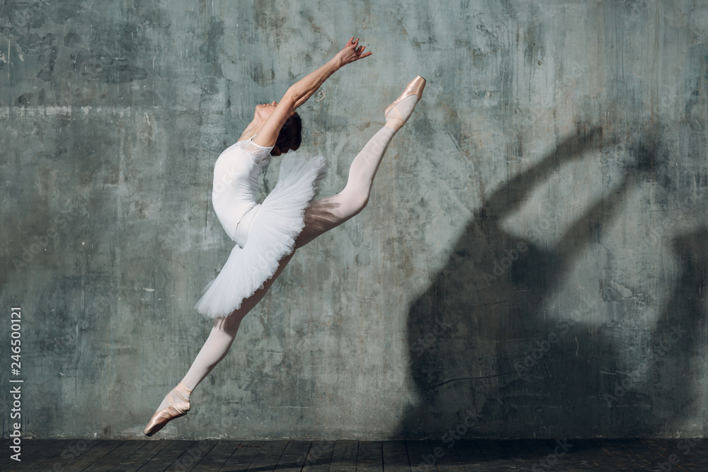 Jumping ballerina . Young beautiful woman ballet dancer, dressed in professional outfit, pointe shoes and white tutu.