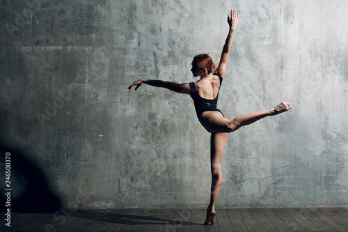Ballerina female. Young beautiful woman ballet dancer, dressed in professional outfit, pointe shoes and black body.