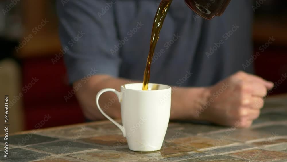 A groggy man overfilling a cup of coffee