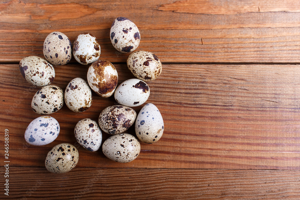 quail eggs on a brown wooden background. top view