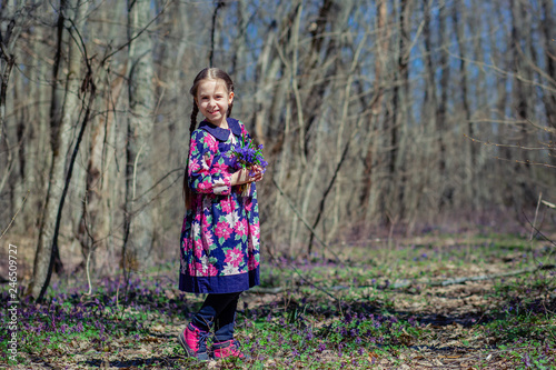 Portrait of a beautiful little girl with corydalis flowers.