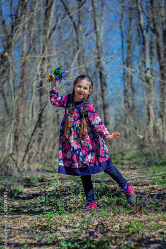 Portrait of a beautiful little girl with corydalis flowers.