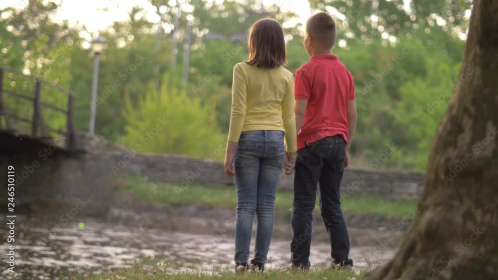 Cute children holding hands at golden sundown