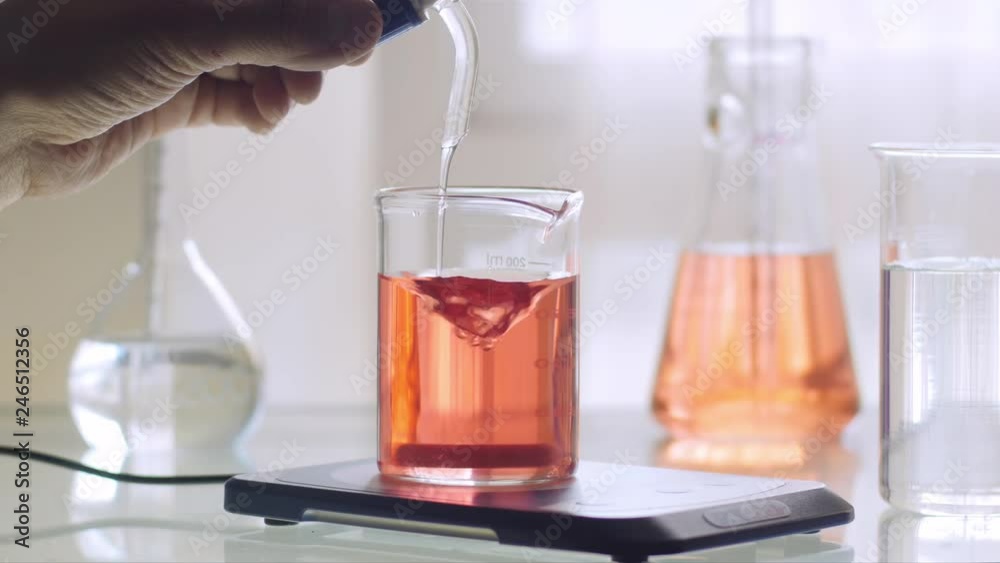 Scientist working with chemical reaction in an Erlenmeyer flask in chemical laboratory Scientist working with chemical reaction in an Erlenmeyer flask in chemical laboratory