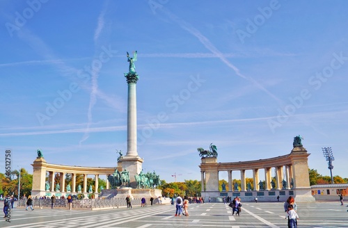 Millennium Monument on the Heroes' Square Hosok Tere under picturesque sky at sunny summer day. Blurred unrecognizable faces of people. One of the most visited attractions squares in Budapest, Hungary © raisondtre