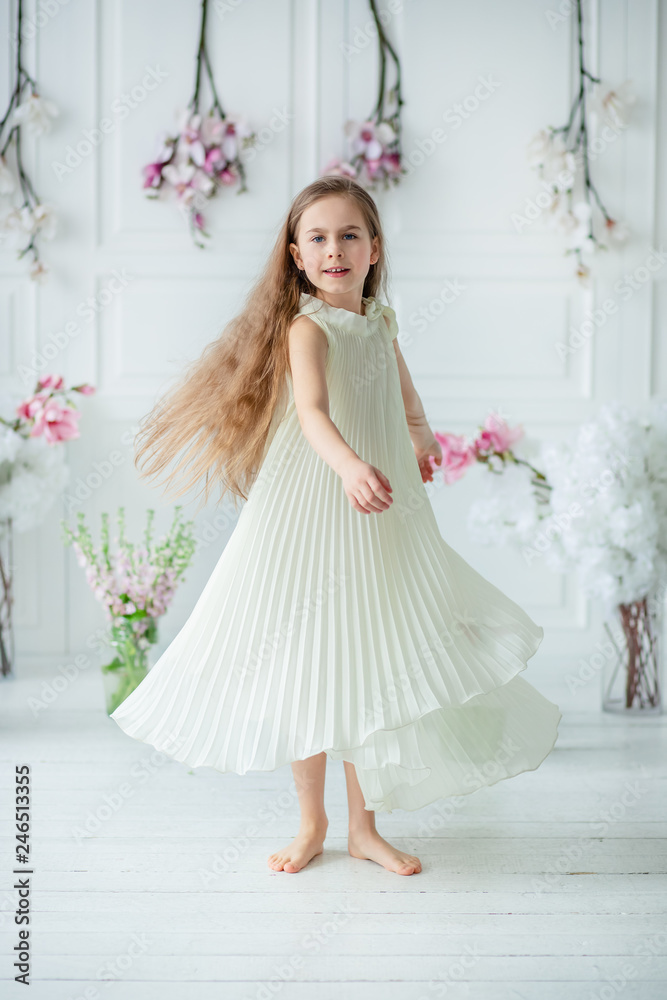 Portrait of a beautiful blue-eyed child, a little girl with a bouquet of tulips in a bright room. Portrait of a beautiful blue-eyed child, a little girl with a bouquet of tulips in a bright room.