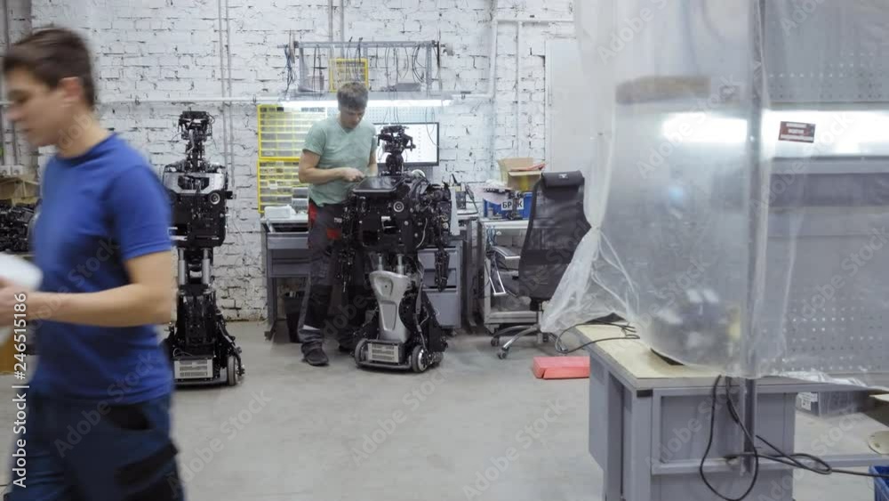 the engineer makes and adjusts the modern robot. the engineer makes and adjusts the modern robot.