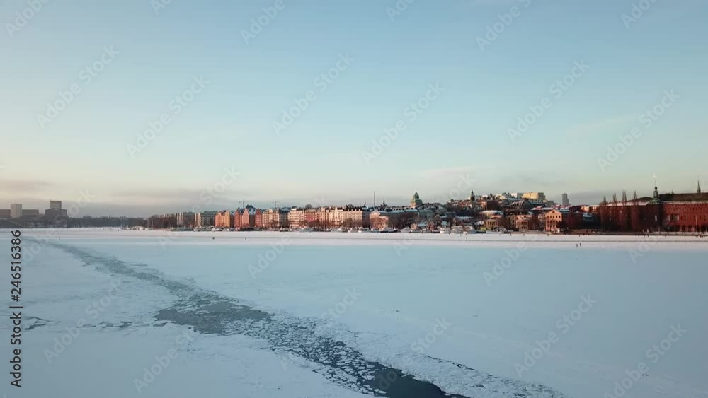 Stockholm low drone flyby over frozen lake with death defying walkers on the ice at sunset_4 Stockholm low drone flyby over frozen lake with death defying walkers on the ice at sunset_4
