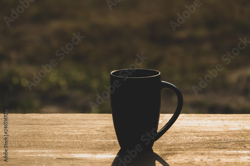 Black hot coffee with morning light on wooden table