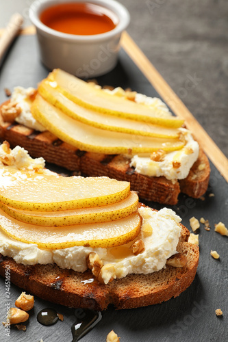 Toasted bread with cream cheese and pear on board