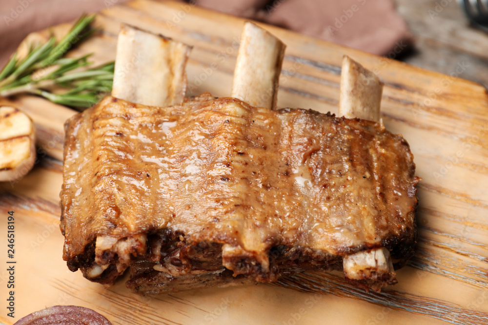Roasted ribs on wooden board, closeup. Tasty meat Roasted ribs on wooden board, closeup. Tasty meat
