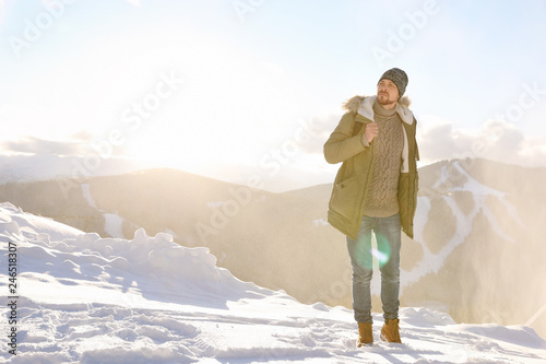 Man spending winter vacation in mountains. Space for text