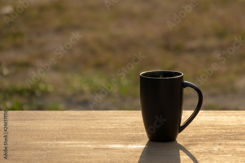 Black hot coffee with morning light on wooden table