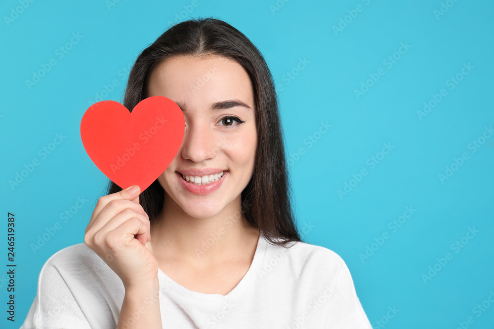Portrait of beautiful young woman with paper heart on color background, space for text Portrait of beautiful young woman with paper heart on color background, space for text