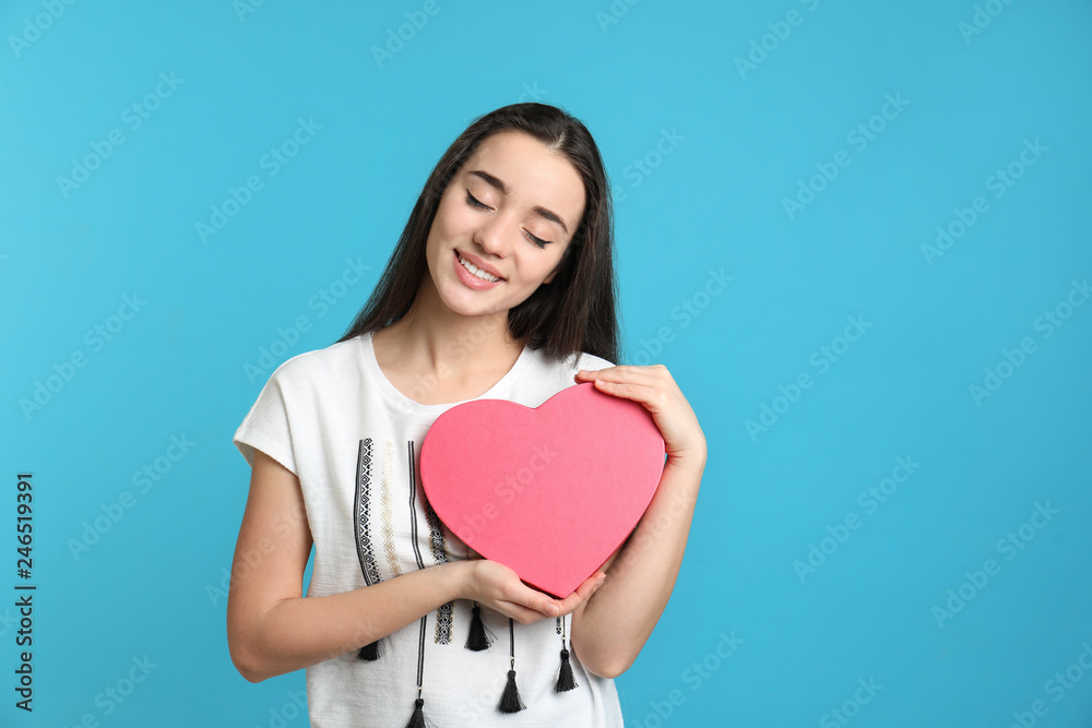 Portrait of beautiful young woman with decorative heart on color background Portrait of beautiful young woman with decorative heart on color background