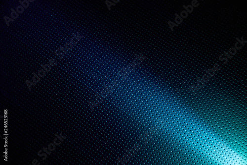 Diagonal bright beam of light on a blue background into a black dot