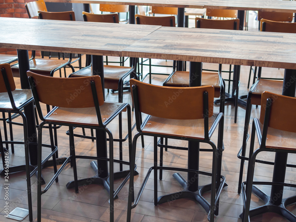 Row of wooden bar stools and wooden table