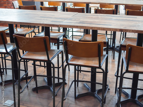 Row of wooden bar stools and wooden table