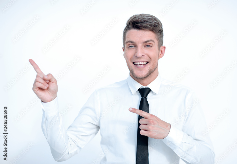 Smiling man pointing upwards and looking at camera Smiling man pointing upwards and looking at camera