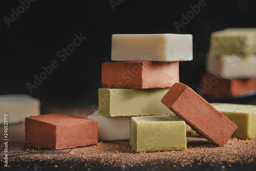 Assortment of soft chocolates on a black background with copy space. Milk and matcha Japanese gourmet chocolate close-up photo
